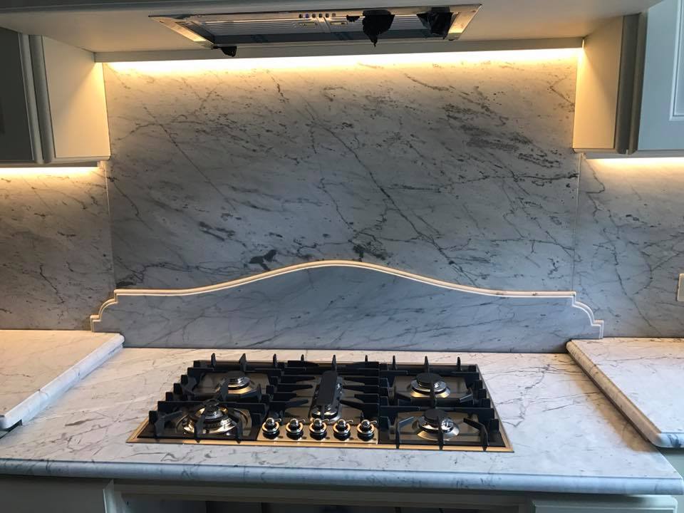 piano cottura con rivestimenti in marmo bianco