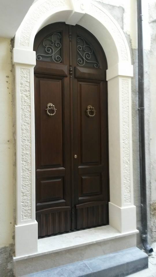 porta ad arco in legno con stipite bianco in pietra