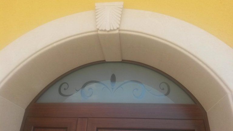 stipite di porta ad arco in pietra bianca