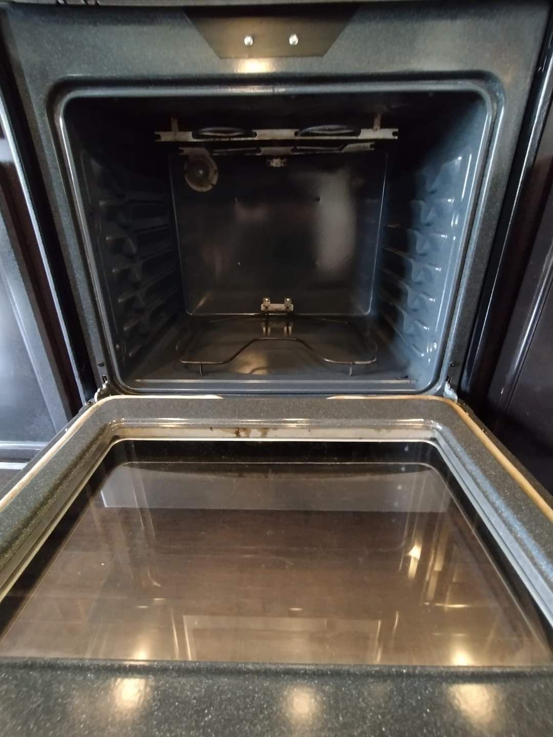 The inside of an oven is shown with the door open.