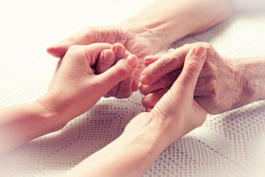 Hands of different ages held together, suggesting care and support.