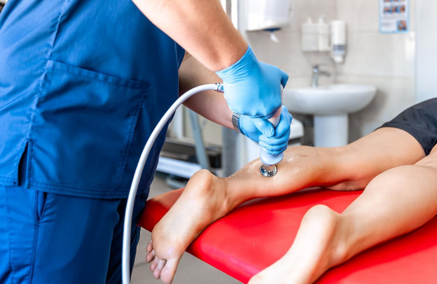 A nurse is using a machine on a patient 's leg.