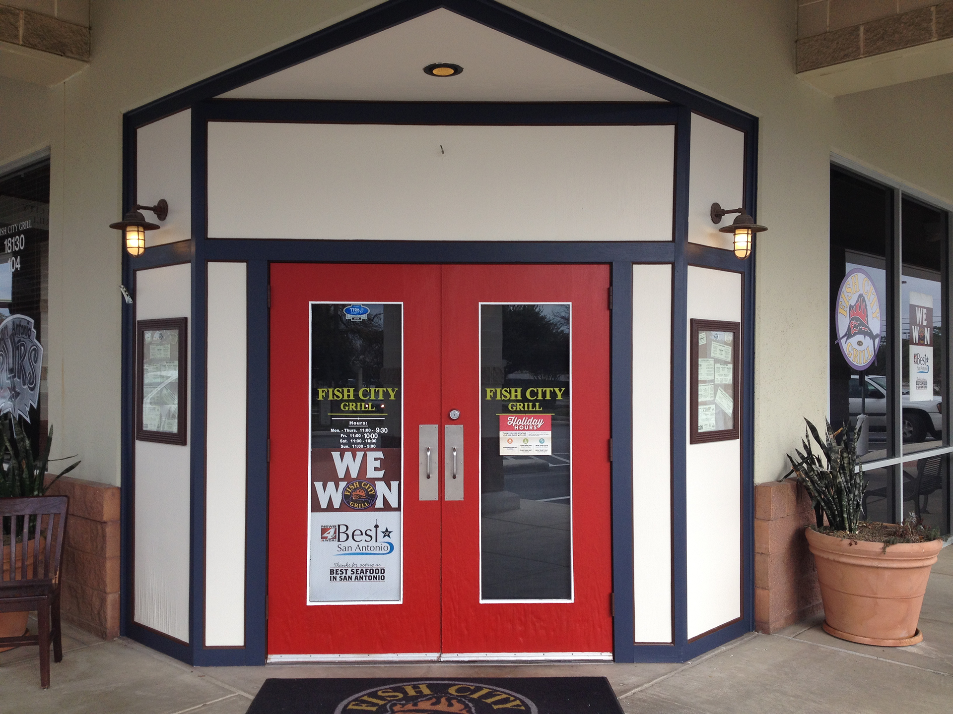 Fish City Grill restaurant entrance with red doors and white and blue trim.