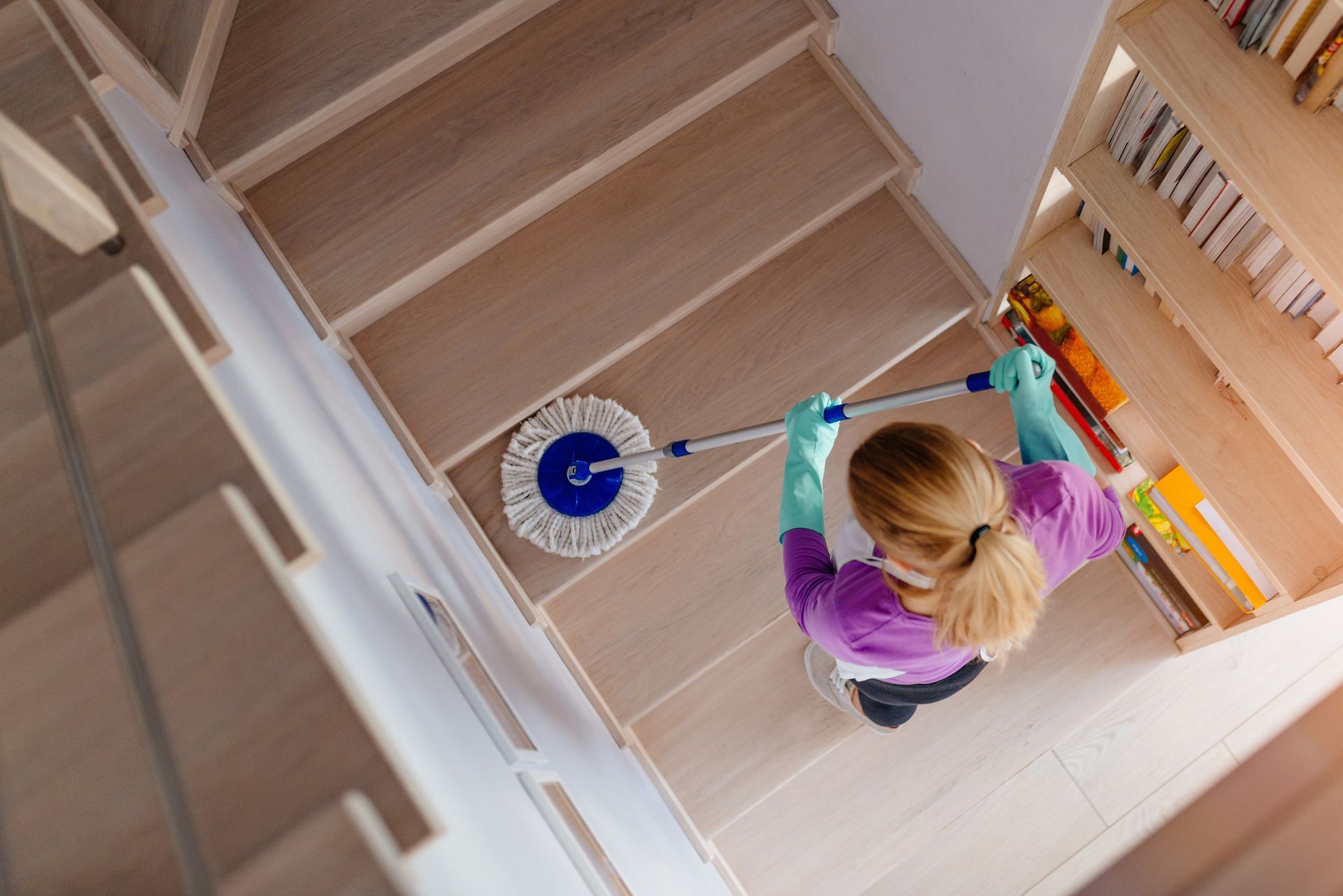 Cleaning the stairs with a mop.