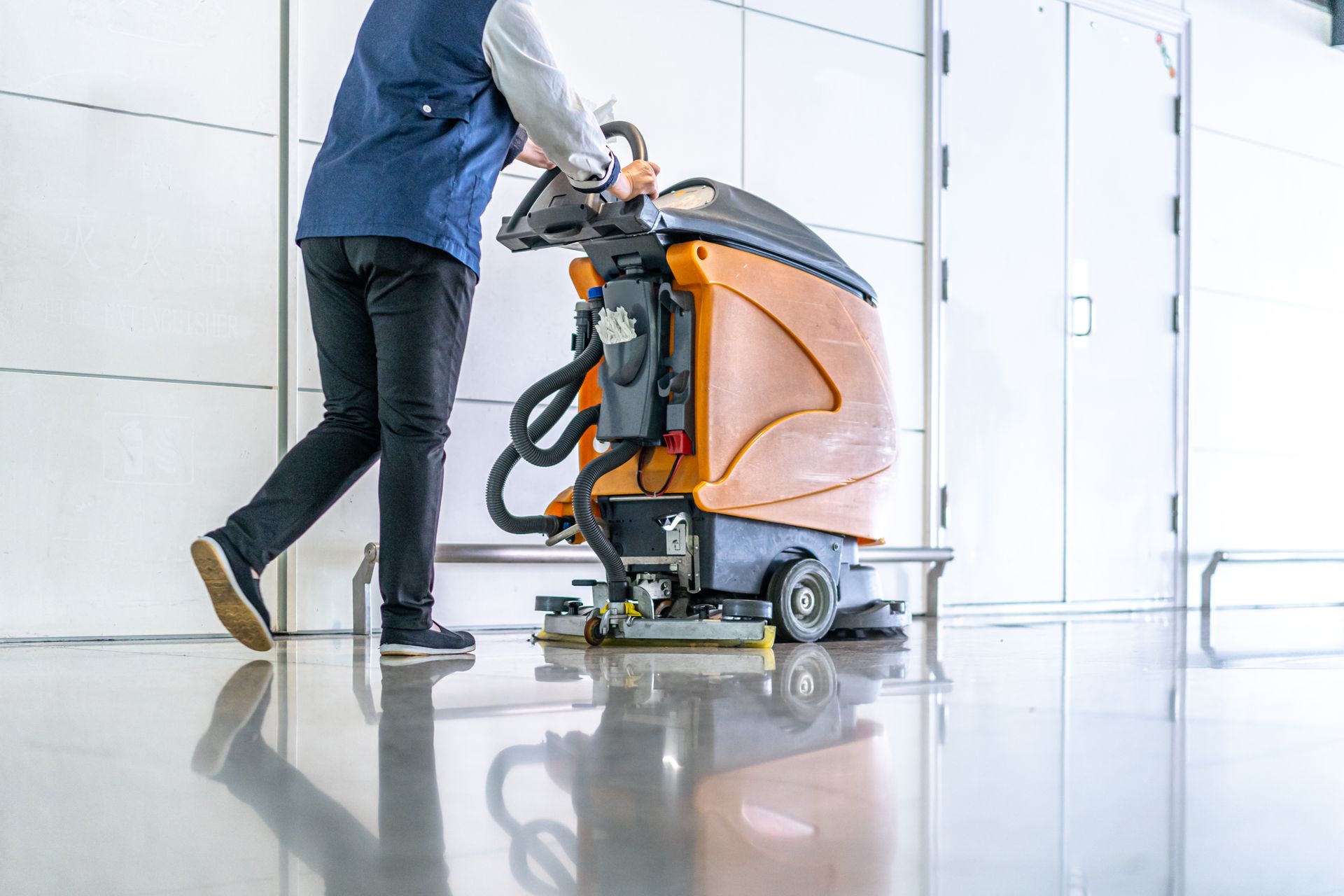 A man is cleaning the floor with a machine.