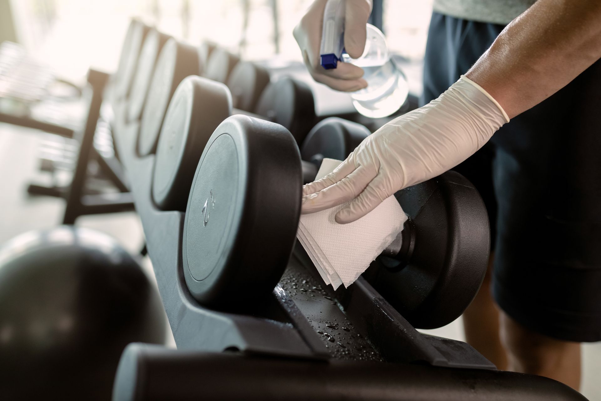 Cleaning a dumbbell in a gym.