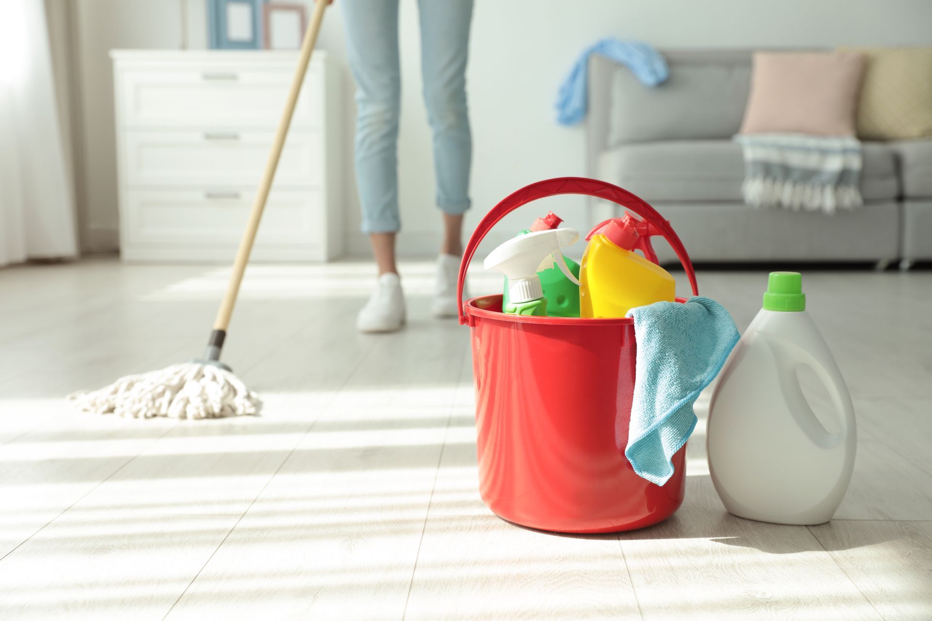 A woman is cleaning the floor in a living room.