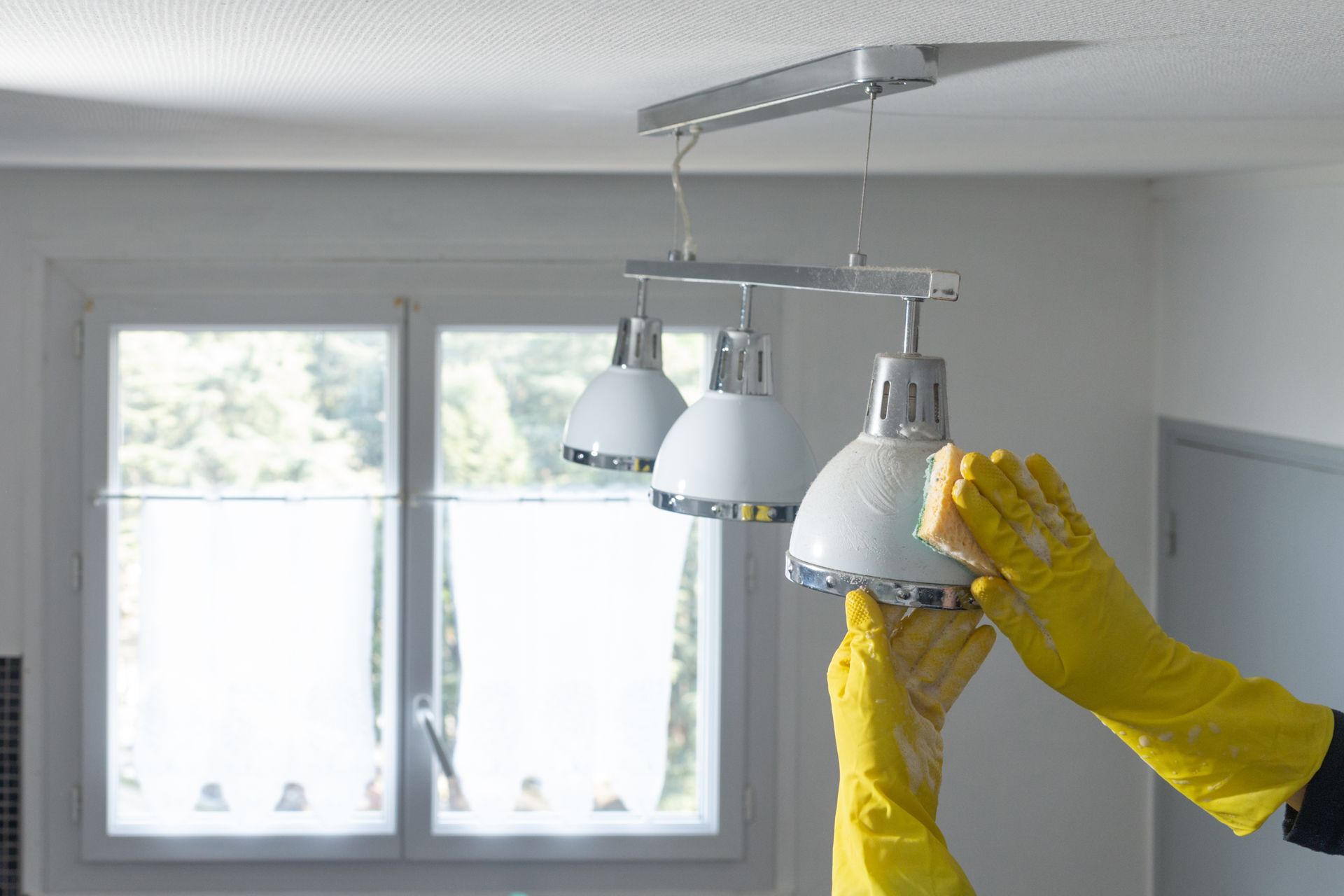 Cleaning a light fixture.