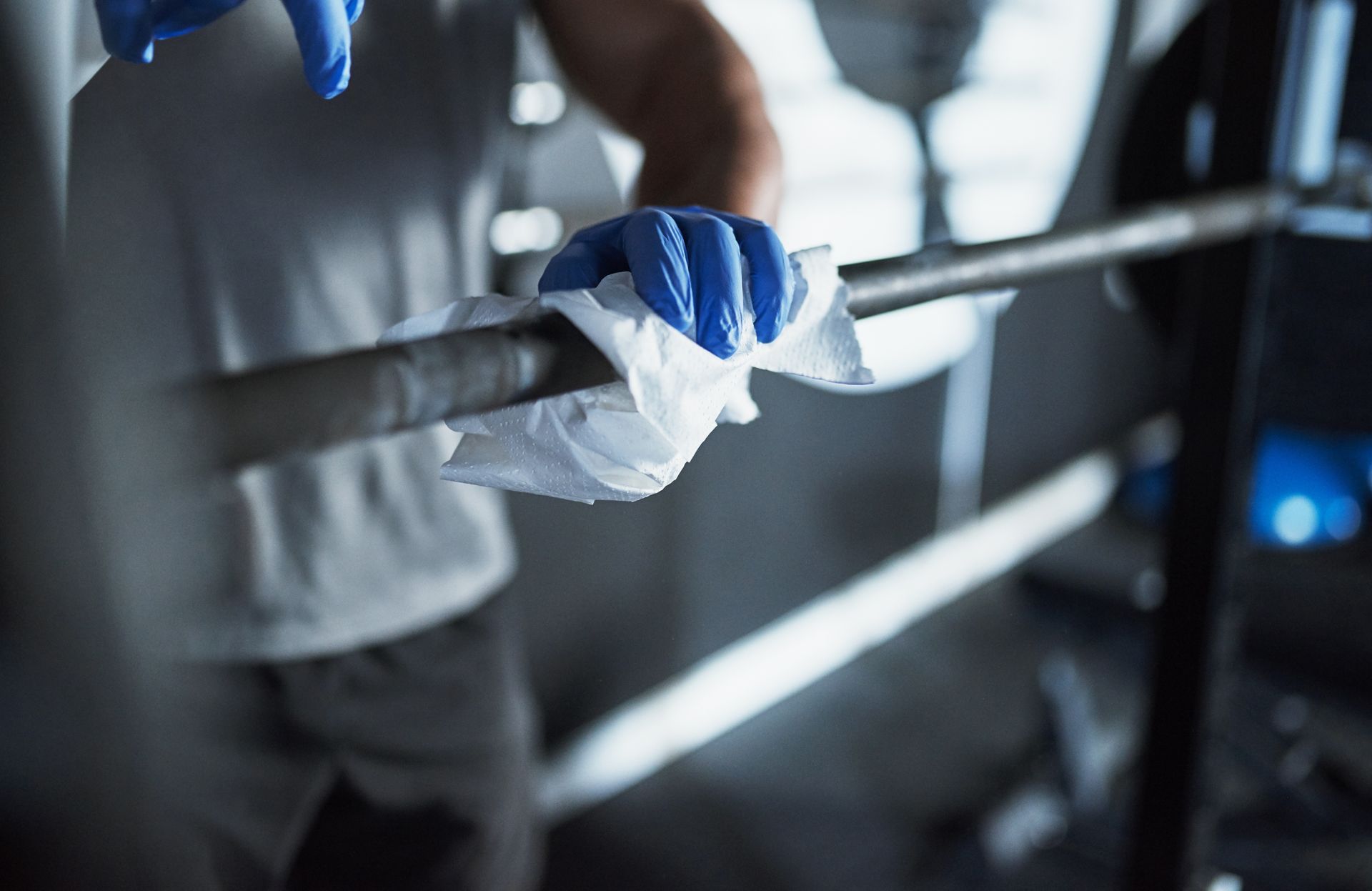 Cleaning a barbell with a towel.