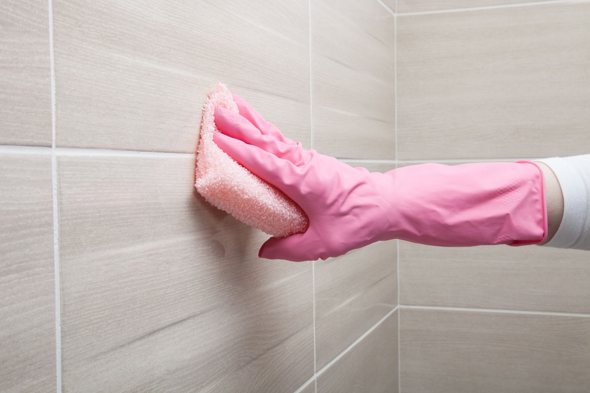 Cleaning a tiled wall.