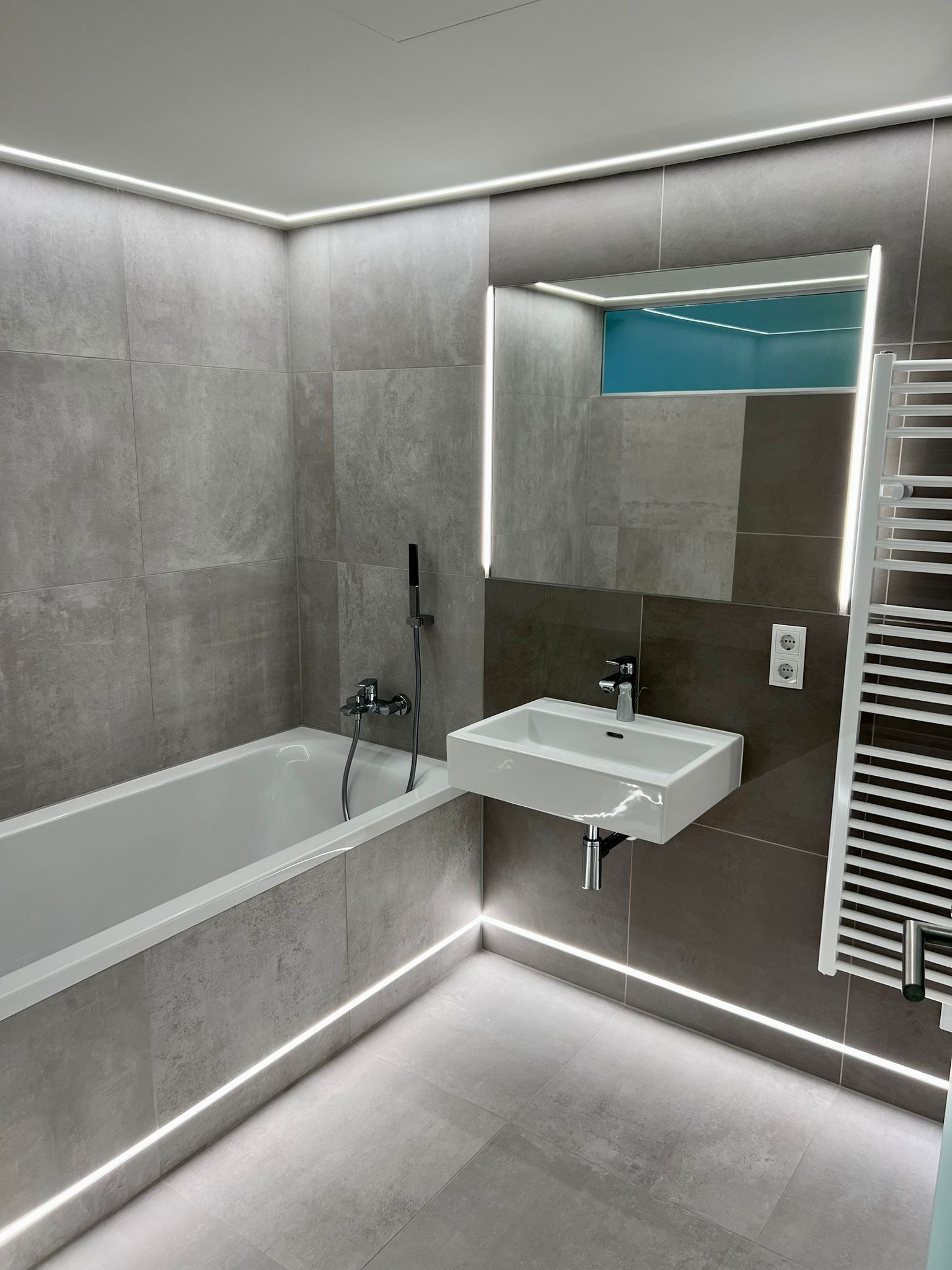 Zimmer mit gemustertem Parkettboden, grün-goldener Tapete und einem Fenster.