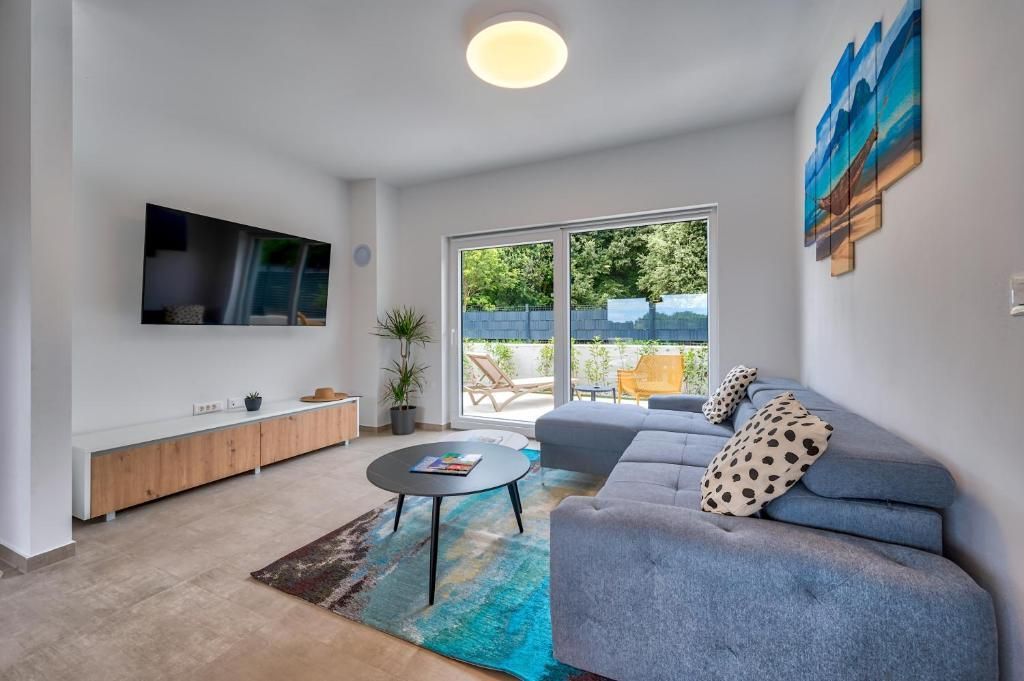 Dnevna soba s kavčem, mizo in televizijo.