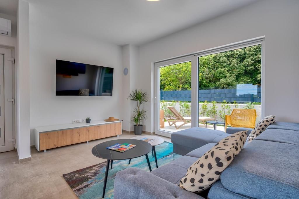 Dnevna soba s kavčem, stolom, mizo in televizijo.