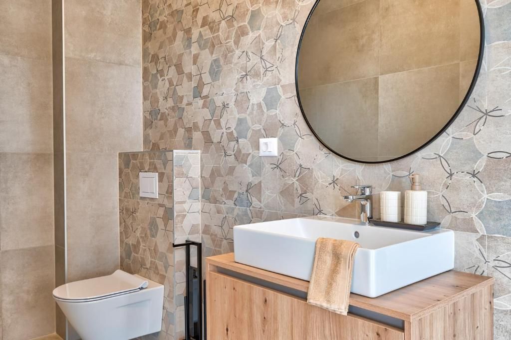 Kopalnica z umivalnikom, straniščem in ogledalom.