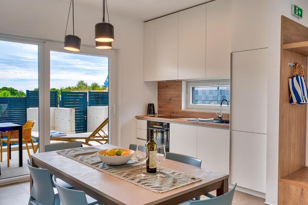 Kuhinja z mizo in stoli ter steklenico vina na njej.