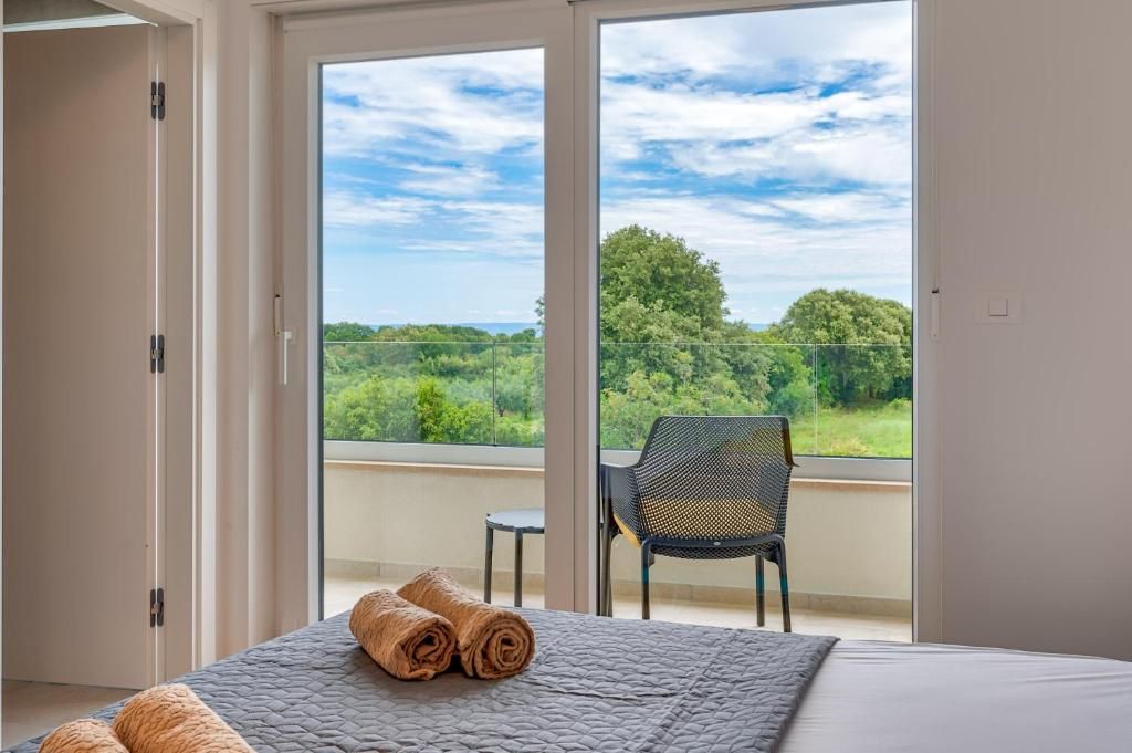 Spalnica z velikim oknom in posteljo z brisačami.