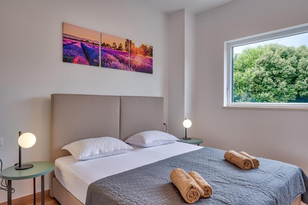 Spalnica z veliko posteljo in oknom.