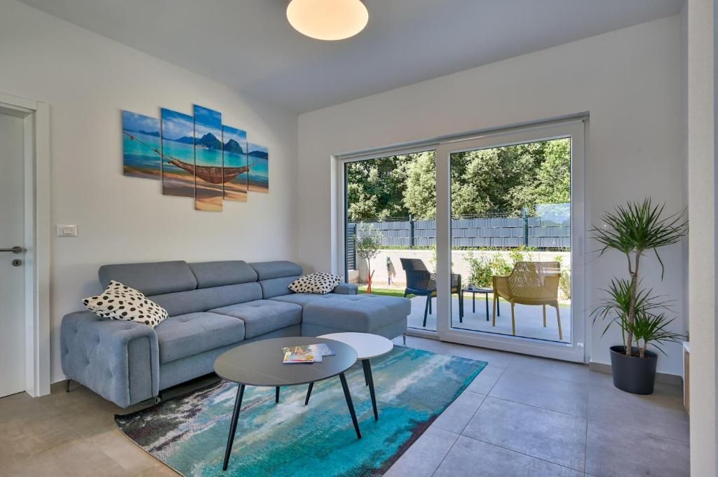 Dnevna soba s kavčem, klubsko mizico in drsnimi steklenimi vrati.