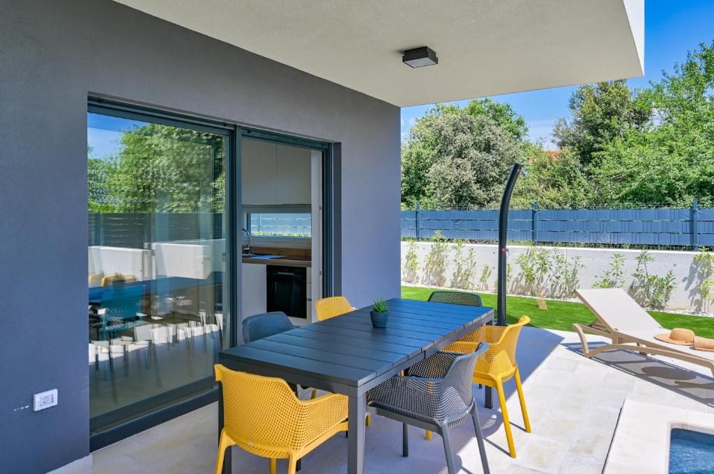 Na terasi hiše je miza in stoli.