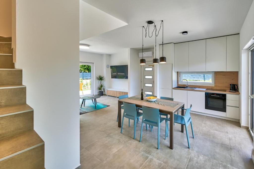 Kuhinja z mizo in stoli ter stopnice, ki vodijo do nje.