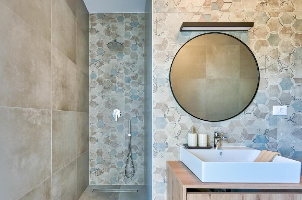 Kopalnica z umivalnikom, ogledalom in tušem.