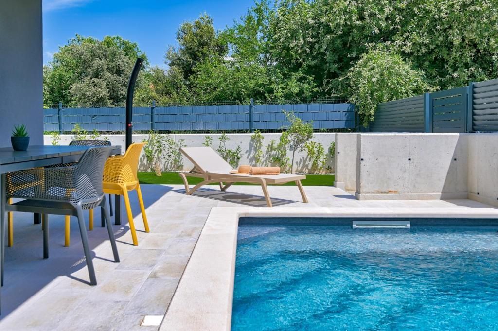 Bazen z mizo in stoli ob njem.