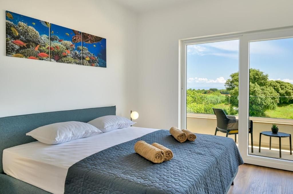 Spalnica z veliko posteljo in velikim oknom.