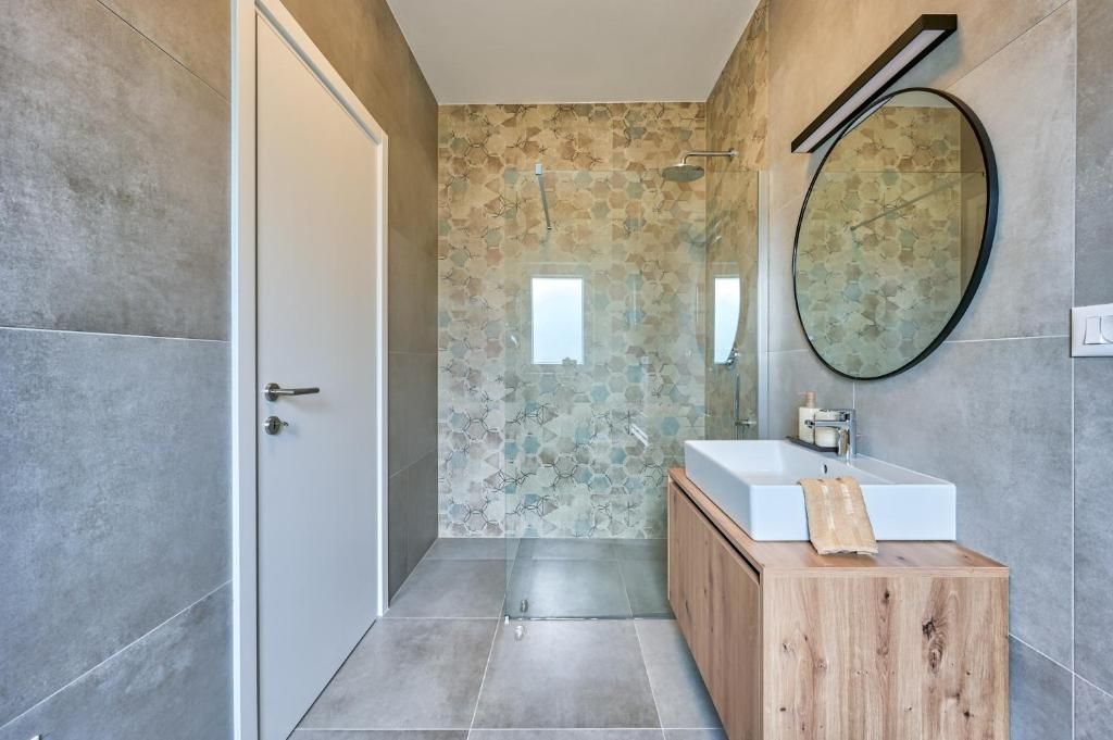 Kopalnica z umivalnikom, ogledalom in tušem.