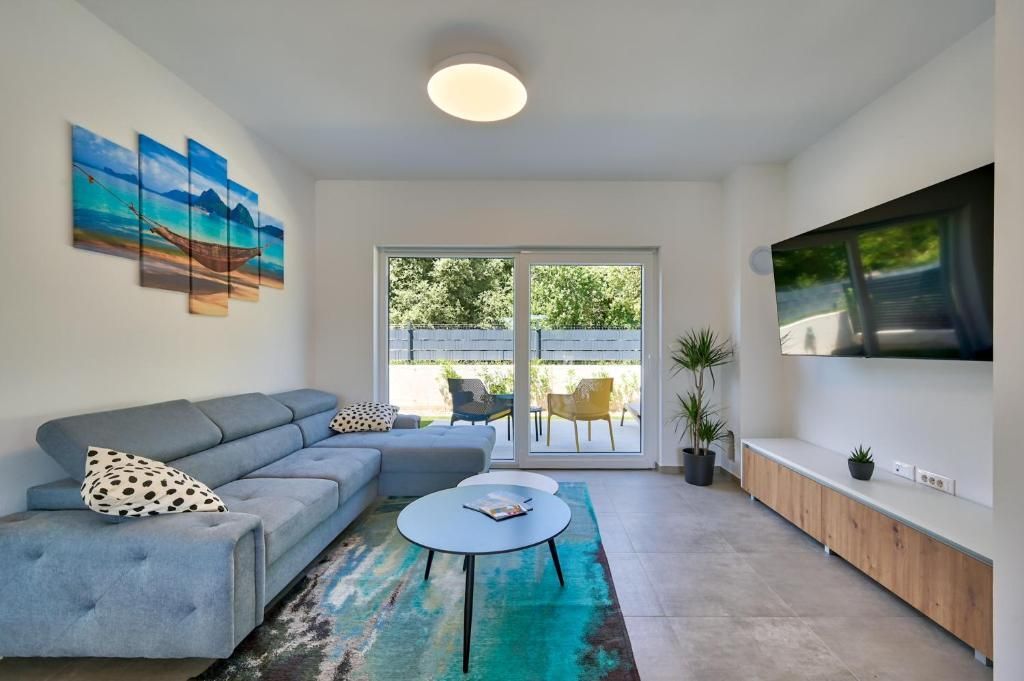 Dnevna soba s kavčem, mizo in televizijo.