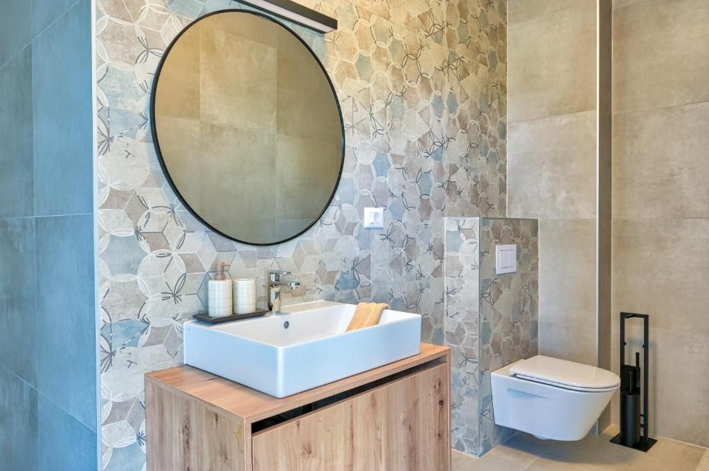 Kopalnica z umivalnikom, straniščem in ogledalom.