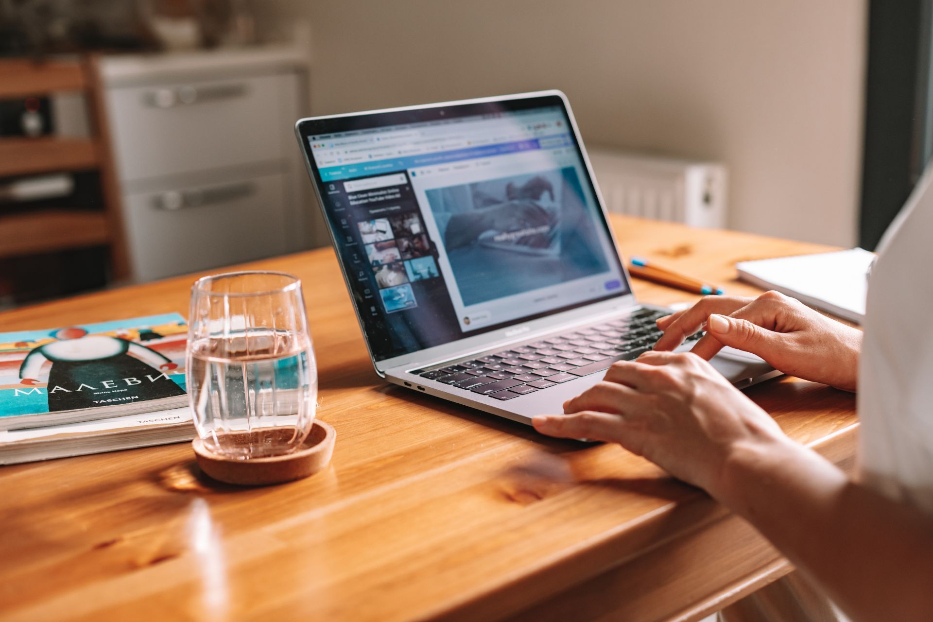 a person is sitting at a table using a laptop computer .