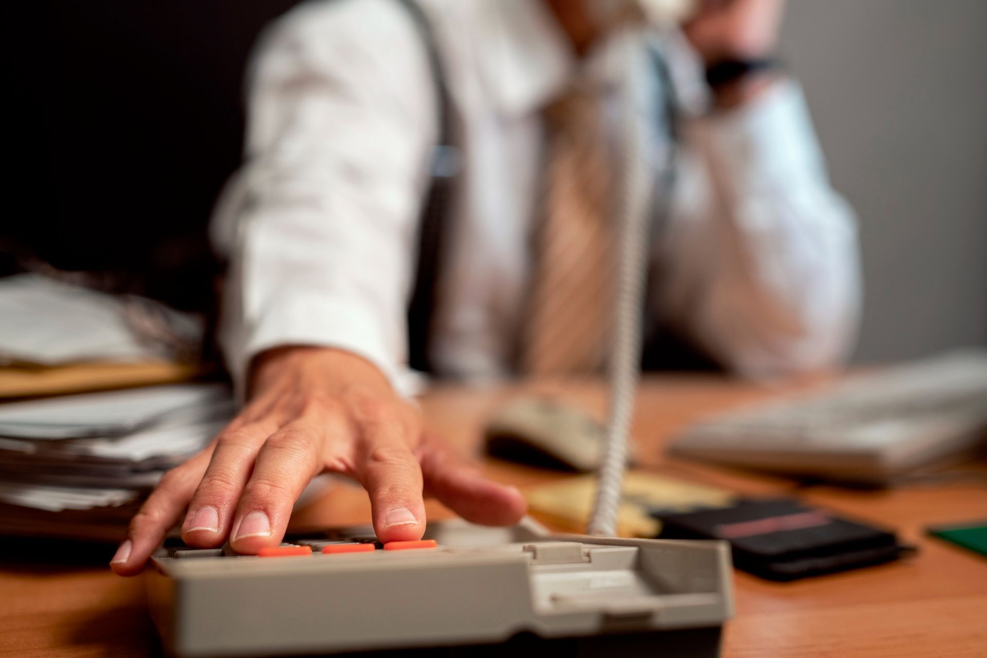 Two people shaking hands over a contract on a desk.