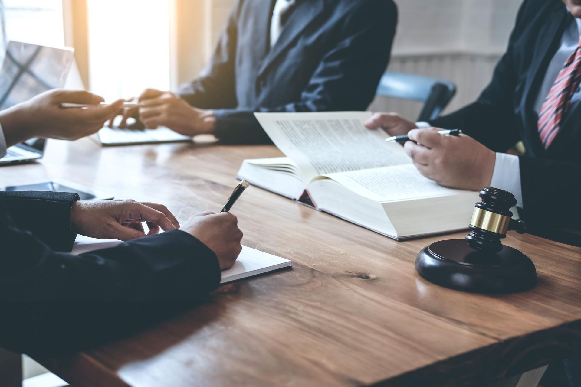 Two people shaking hands over a contract on a desk.