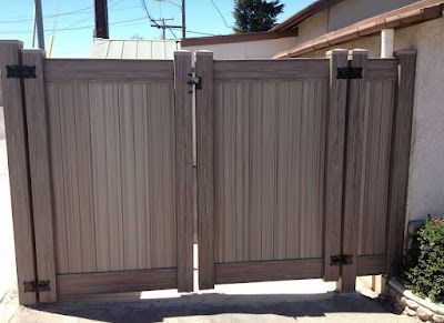 A wooden gate is sitting in front of a house.