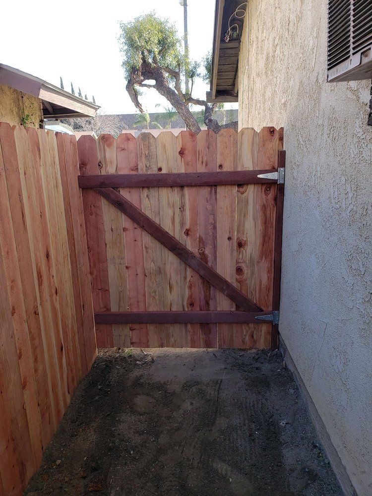 A wooden fence with a gate in the backyard of a house