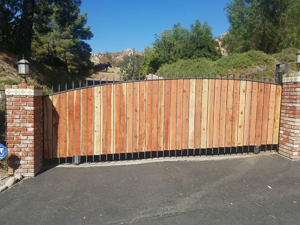 A wooden gate with a brick pillar behind it