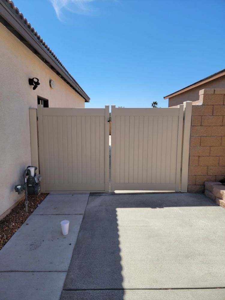A white fence with a brick wall behind it