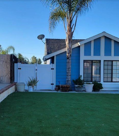 A blue and white house with a palm tree in front of it