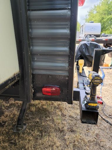 A drill is attached to the back of a trailer.
