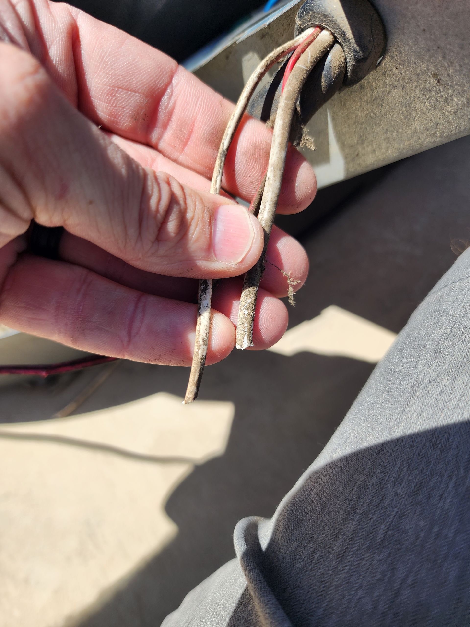 A close up of a person holding a wire in their hand