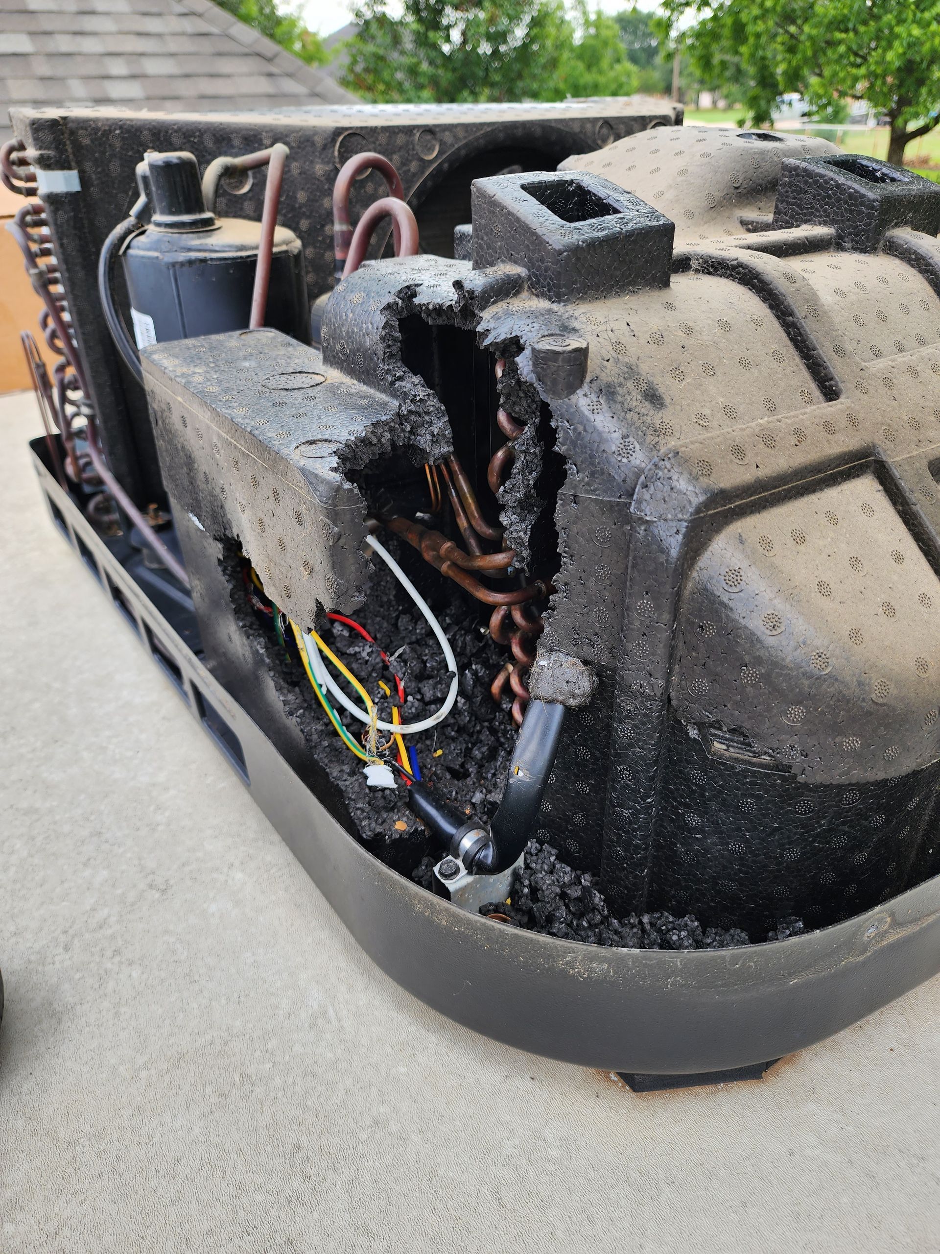 A broken air conditioner is sitting on top of a roof.