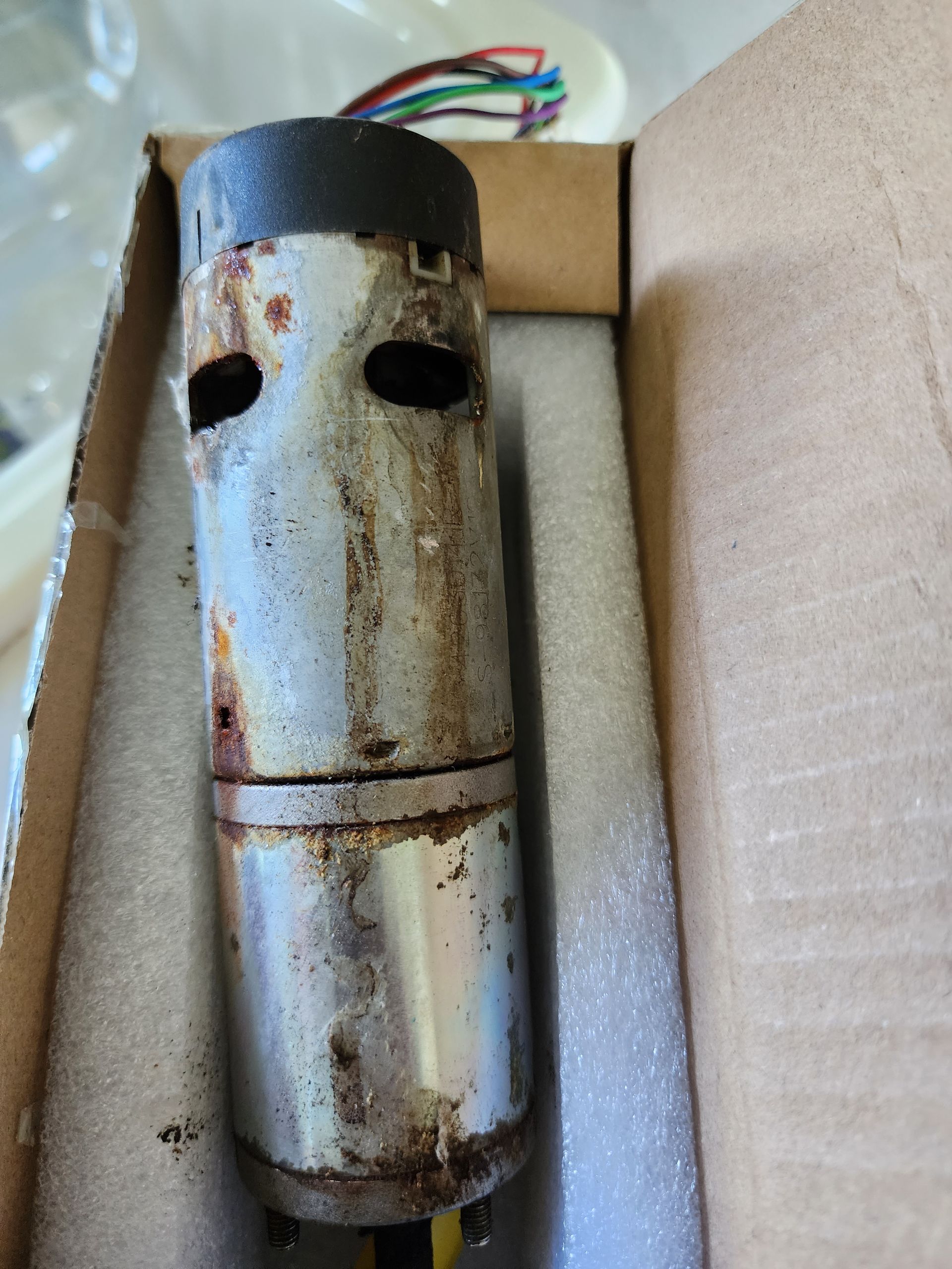 A close up of a rusty metal object in a box