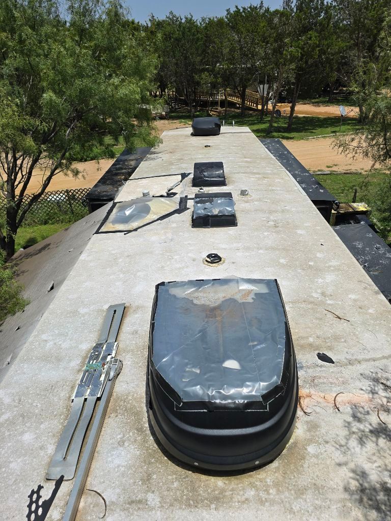 The roof of a building with a lot of windows and trees in the background.