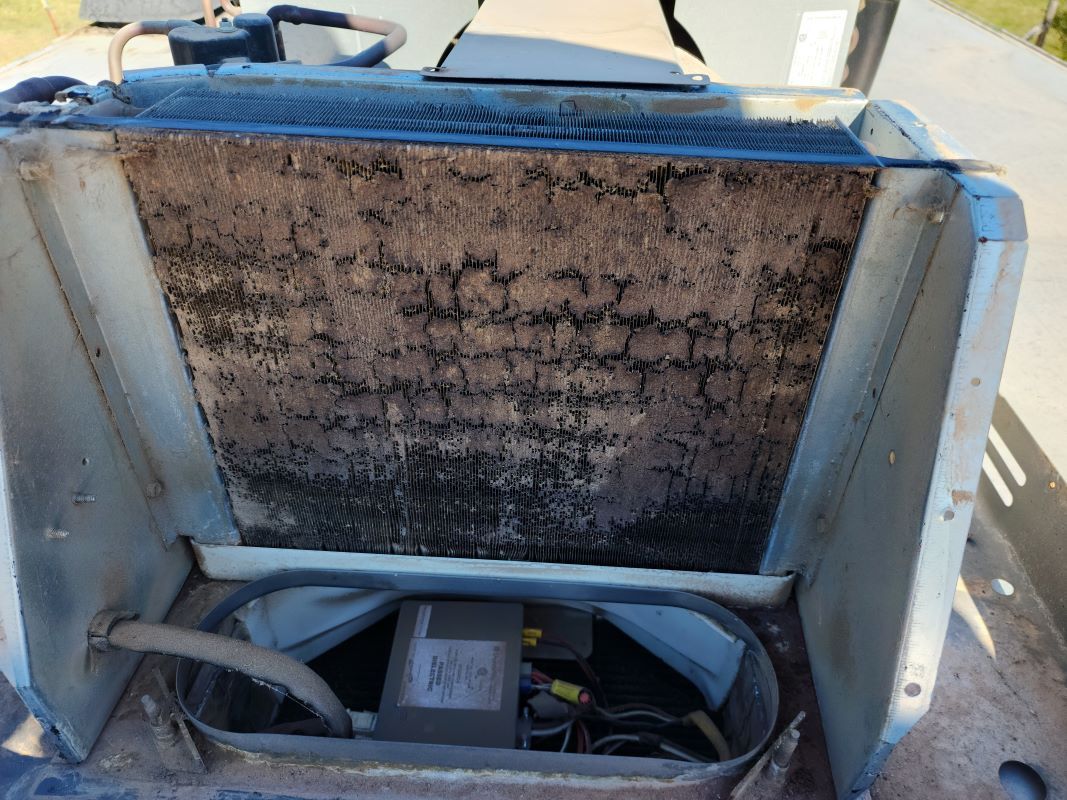 The inside of a dirty air conditioner with a fan.