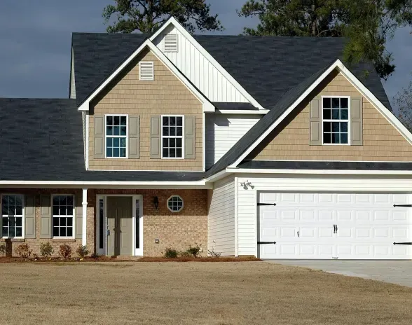 A house with a white garage door and a black roof