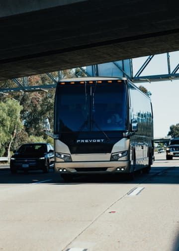 Charter bus traveling on the road for group transportation services in Orange County