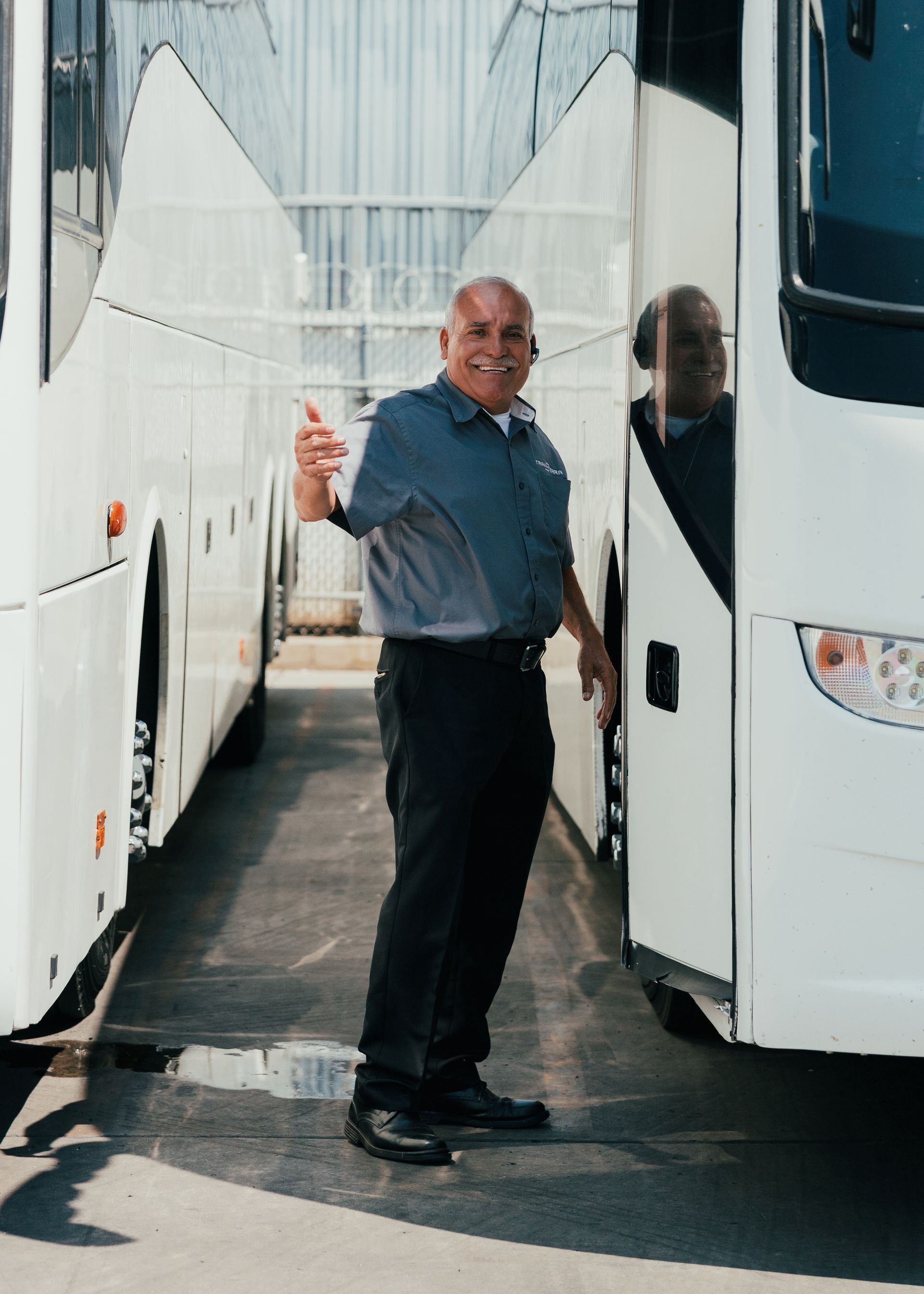 Professional charter bus driver greeting passengers in San Diego.