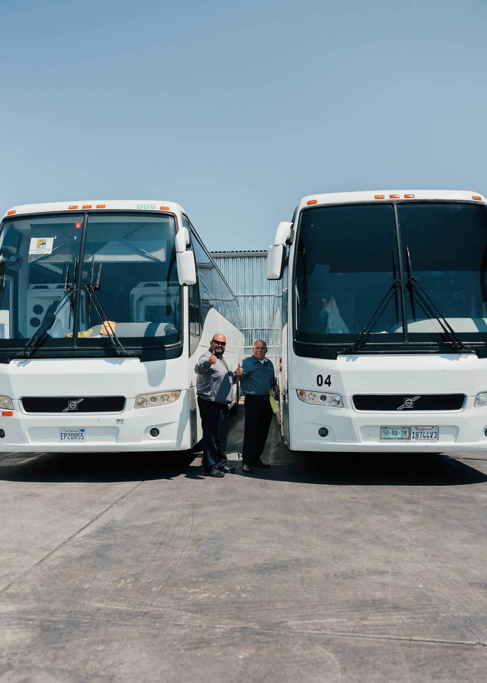 San Diego charter bus drivers standing ready to assist passengers for a scheduled bus rental trip
