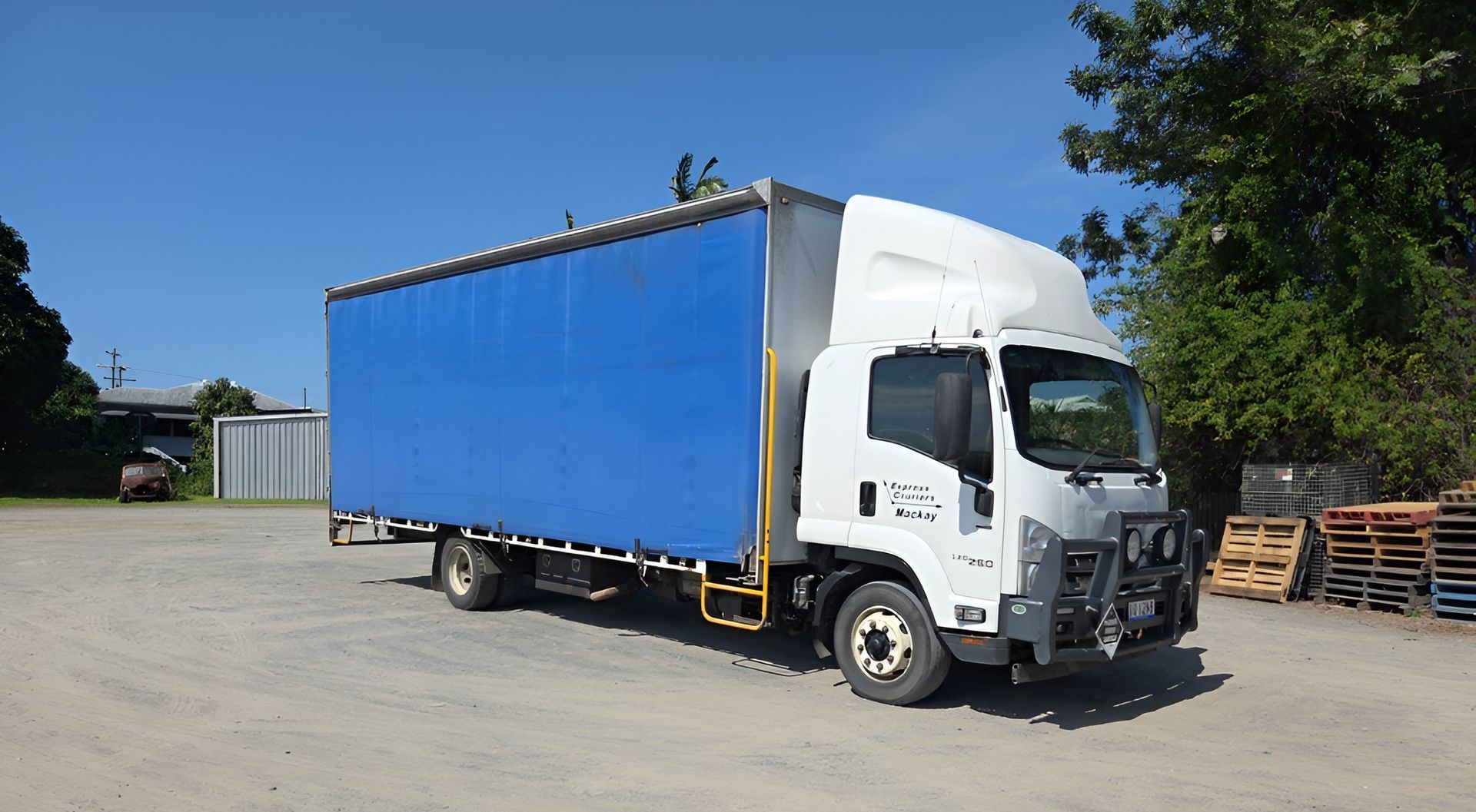 A Delivery Man is Handing a Box to Another Man in Front of a Van — Express Couriers Mackay in Mackay Harbour, QLD