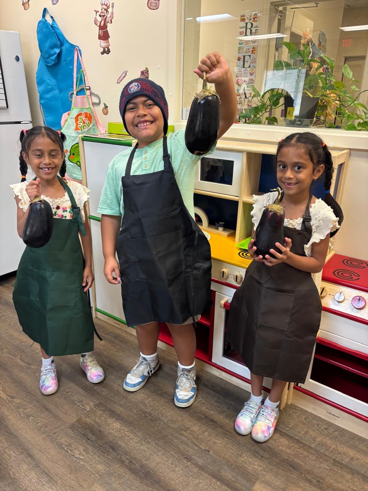 Montessori child holding eggplant in the classroom